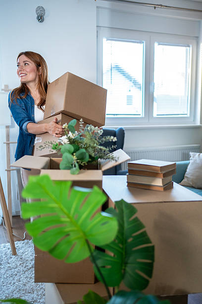istock Woman carrying cardboard boxes into new apartment 2235626192