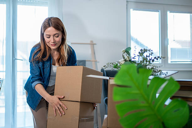 istock Woman lifting stack of cardboard boxes in new apartment 2235626329
