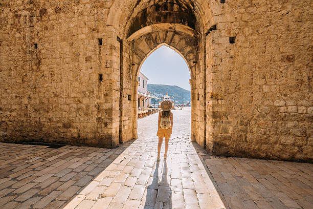 istock Woman Walking Through Historic Stone Archway 2235627381