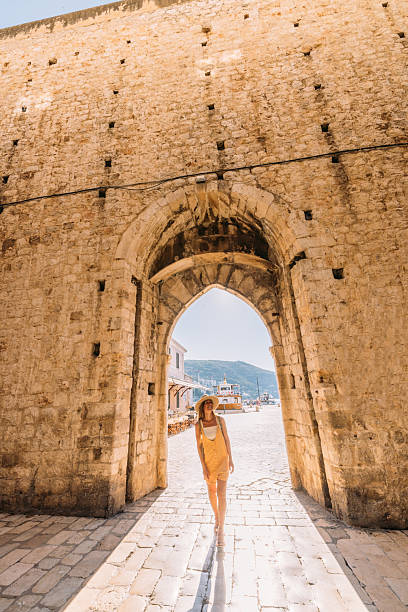 istock Woman Walking Through Historic Stone Archway 2235627467