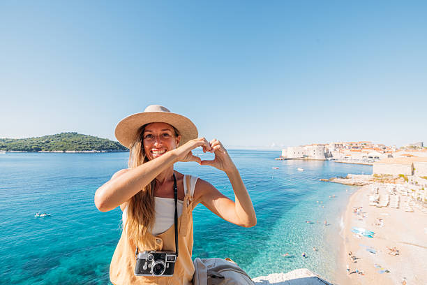 istock Woman Making Heart Shape Hand Gesture Seaside 2235627828