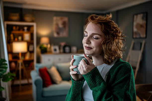 istock Young woman relaxing with a warm beverage at home 2235628077