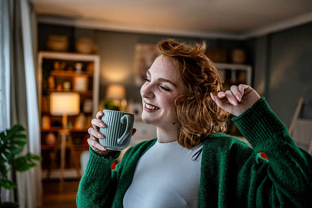 istock Young woman relaxing at home, drinking coffee and stretching 2235628086