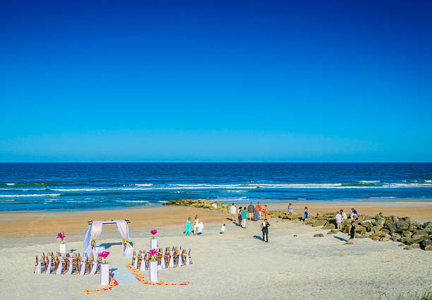 Group of diverse friends having fun at the beach, drink and dance in the waves on a sunny day