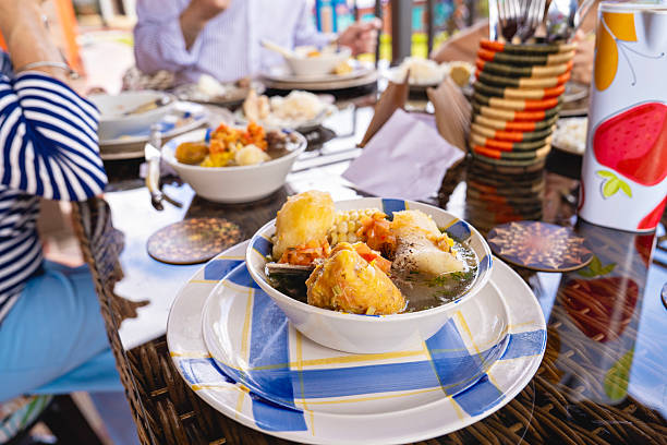 Multigenerational Latin family sharing a homemade lunch on the terrace, with a traditional dish served on the table, representing tradition, togetherness, and family lifestyle.