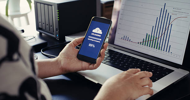 istock Woman uploading files to cloud using her smart phone 2235631417