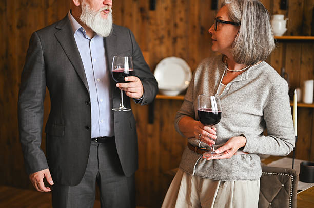 istock Elegant senior couple enjoying wine in rustic dining room 2235632550