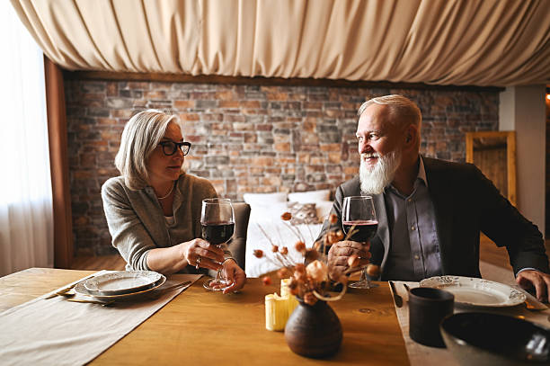istock Senior couple enjoying romantic dinner with wine at home 2235632625