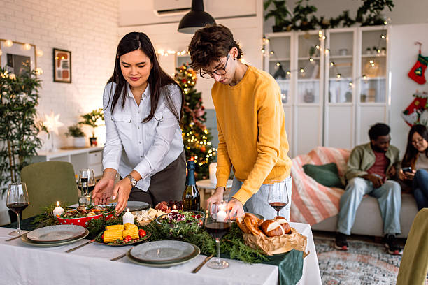 istock Young couple setting and arranging dining table for christmas eve celebration. 2235636309