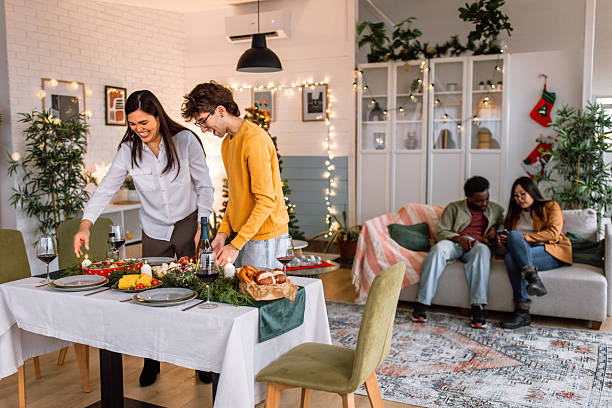 istock Young couple setting and arranging dining table for christmas eve celebration. 2235636311
