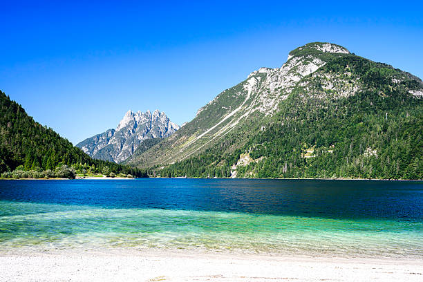 The beautiful blue green turquoise Predil lake in Italy, with mountains in background, close to the Slovenian border.