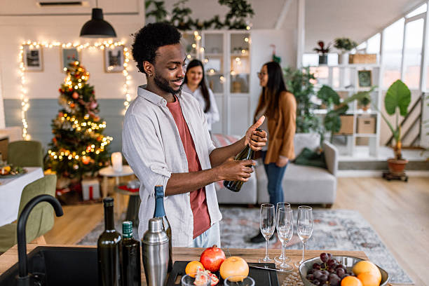 istock A black man opens a bottle of champagne during New Year's Eve 2235637549