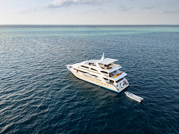 istock Luxury white yacht navigating crystal-clear tropical waters, accompanied by smaller vessel, representing high-end maritime leisure and relaxation 2235638789