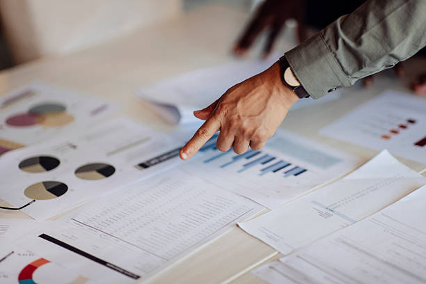 istock Close-Up of Hands Reviewing Data and Charts on a Table 2235638897