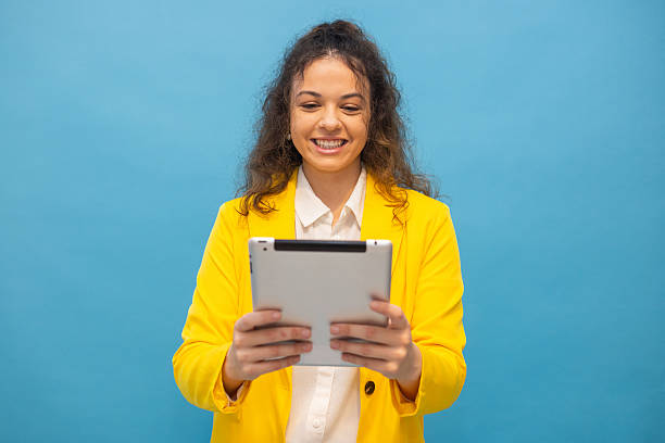 istock Smiling businesswoman working on digital tablet, representing modern workplace efficiency and technological connectivity 2235645599