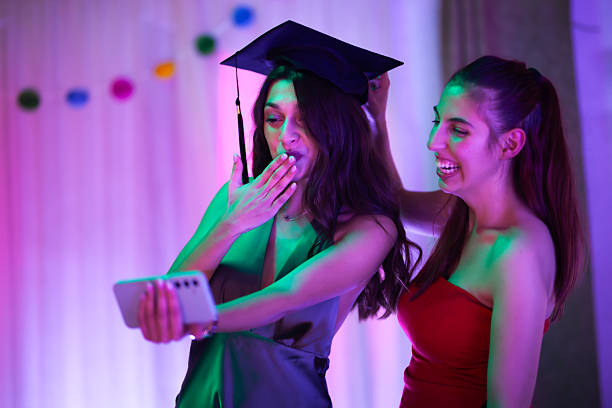 istock Graduate celebrating with friend while taking a selfie during a joyful party 2235647831