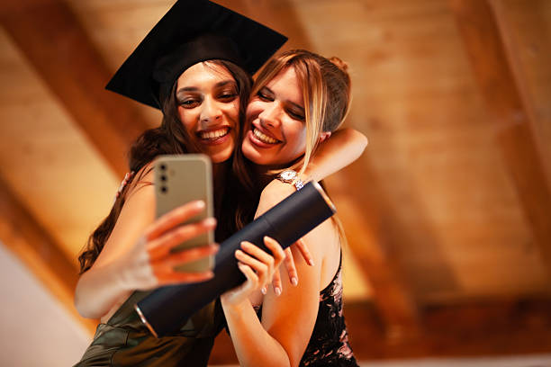 istock Two women celebrating graduation and taking a selfie with a diploma 2235647851