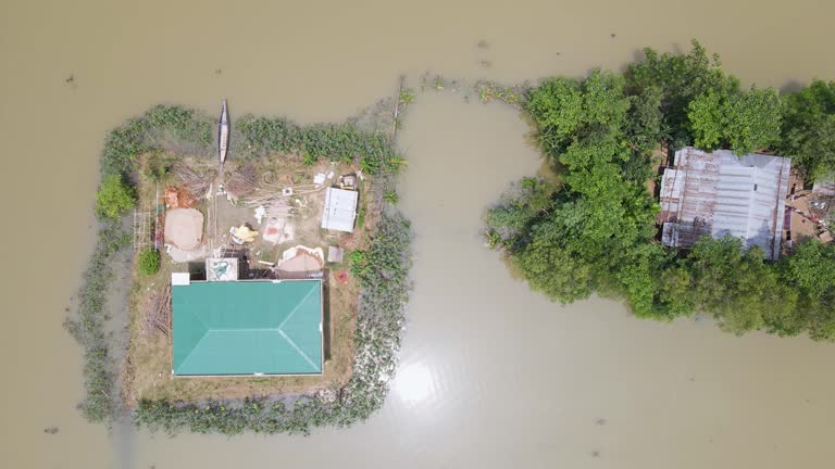 Aerial view of flood affected houses surrounded by muddy water and trees in Bangladesh, South Asia