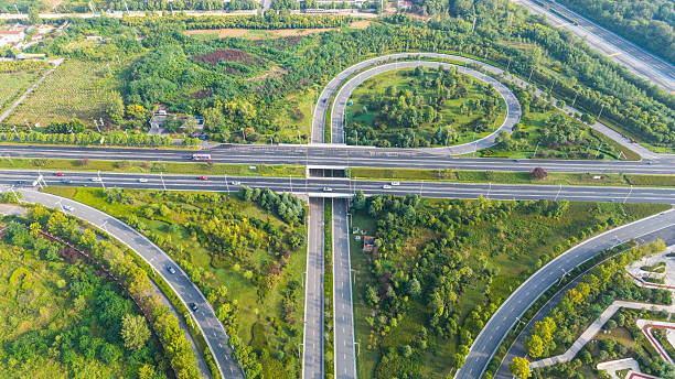 istock Aerial view of a multi - level highway interchange surrounded by greenery 2235655853