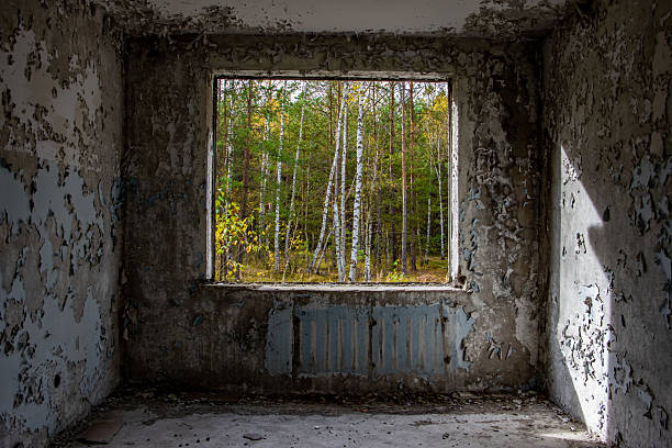 View through the hole for a windows in a damaged abandoned panel house.