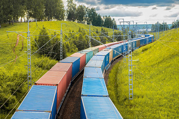 istock Two freight trains move in parallel, carrying colorful containers along railway tracks. Set against a backdrop of vibrant green hills, the natural beauty enhances the scene as the trains 2235661765