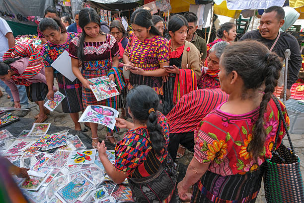 Chichicastenango, Guatemala - July 3, 2025: Women buying embroidery patterns at the Santo Tomas Market in Chichicastenango, Guatemala.