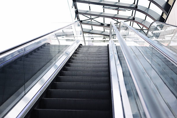 istock Modern escalator going up. Glass railing reflections. Urban public transport station interior. Steel construction design. 2235672479
