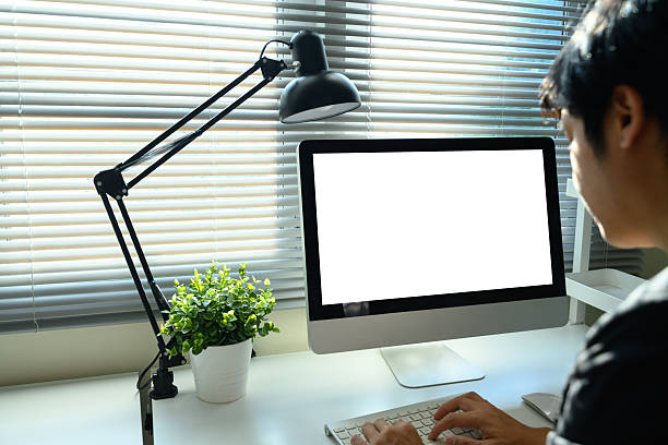 istock Businessman working in modern home office with blank white screen and natural daylight 2235677773