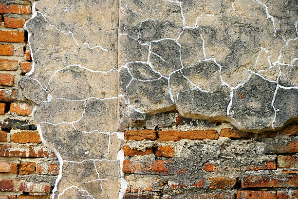 This image showcases a textured wall featuring cracked plaster against exposed brick, illustrating the beauty of decay and weathering in architecture.