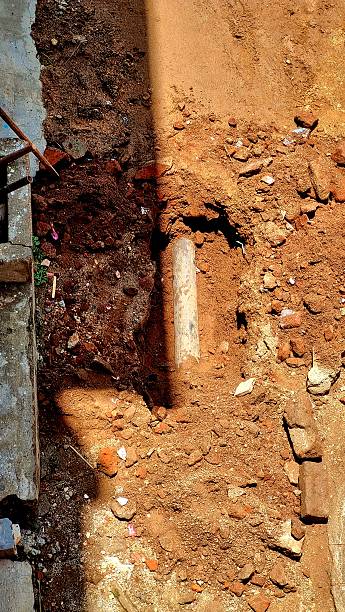 istock Exposed underground pipeline during excavation and maintenance work at Madurai corporation site, with soil, debris, and broken bricks visible around the dug-up area. 2235685425