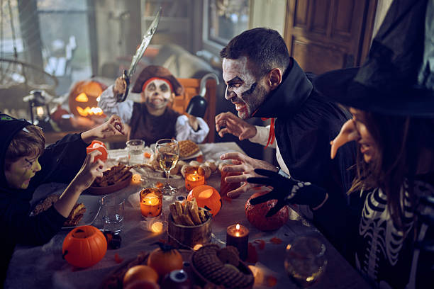 istock Carefree family having fun on Halloween at dining table. 2235686190