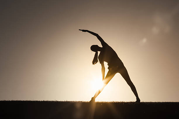 Silhouette of  sport woman striking a graceful yoga pose against the glowing. This image perfectly represents the essence of meditation, wellness, and the pursuit of balance in life.