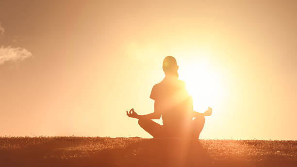 istock Woman meditating outdoors at sunset. 2235686615