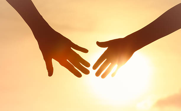 istock Hands Reaching Toward Each Other in Sunset Glow Symbolizing Unity, Connection, and Hope. 2235686640