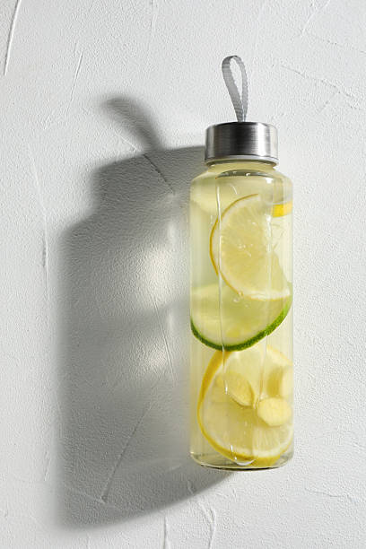 istock Lemon water with lime in bottle on white table, top view. Space for text 2235689606