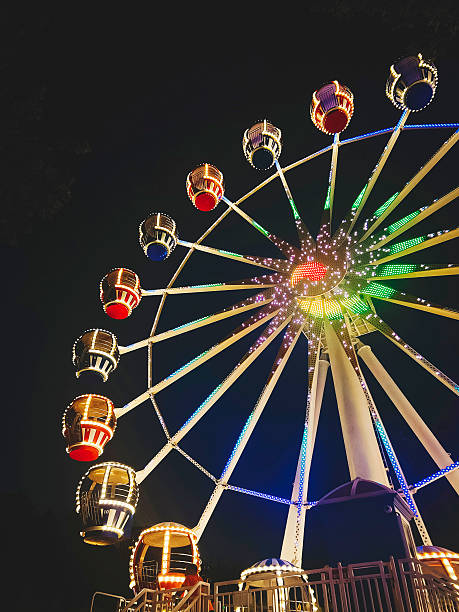 istock dazzling Ferris wheel, its lights create a vibrant display against the night sky. The colorful design and dynamic structure. 2235690721
