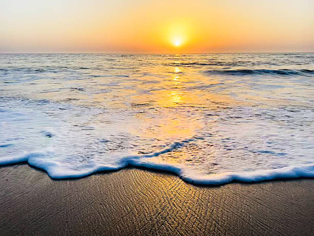 istock Ocean waves washing ashore at sunset on sandy beach 2235690767