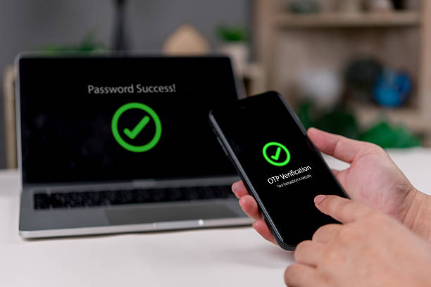 istock Security Password , Hands confirm OTP on a smartphone while the laptop shows success in a clean workspace to finish login, 2FA, smartphone mobile authentication, and identity protection concept. 2235693908