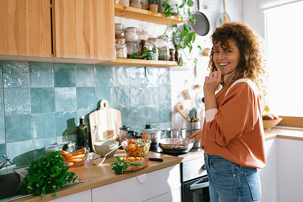 istock Woman eating green celery in kitchen 2235694926