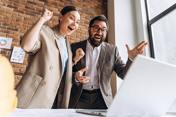 istock Excited architects celebrating success looking at laptop in the office 2235695101