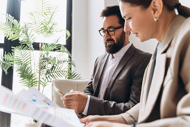 istock Business partners analyzing financial charts and using smartphone in office 2235695171