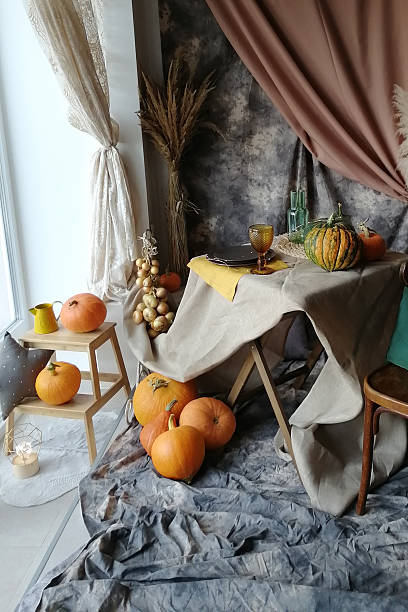 istock Autumn interior decoration with pumpkins on a table and floor. Fall Thanksgiving, Halloween holiday harvest display with dry grass. 2235697062