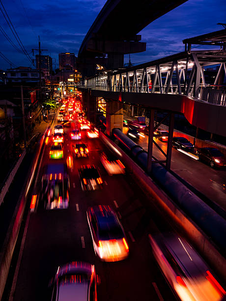 Traffic Light Trails at Twilight from Pedestrian Bridge - Urban Rush Hour with Motion Blur and City Skyline