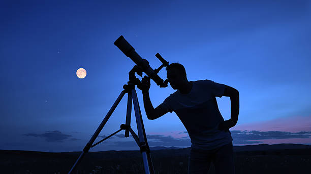 istock Amateur astronomer using telescope for watching stars, Moon, planets and other celestial objects from a field in nature. 2235700636
