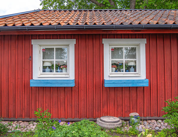 istock Charming Red Wooden House with Blue Window Frames 2235701353