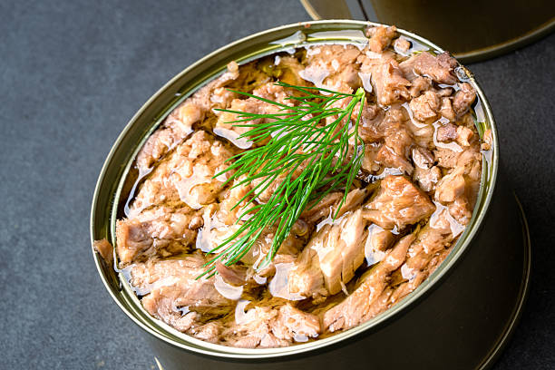 Canned tuna in brine isolated on black background