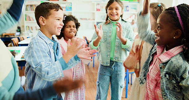 istock Education, kids and applause in classroom together for learning, growth or development. Energy, smile and happy student children in back to school class for knowledge, excited friends and academics 2235704578