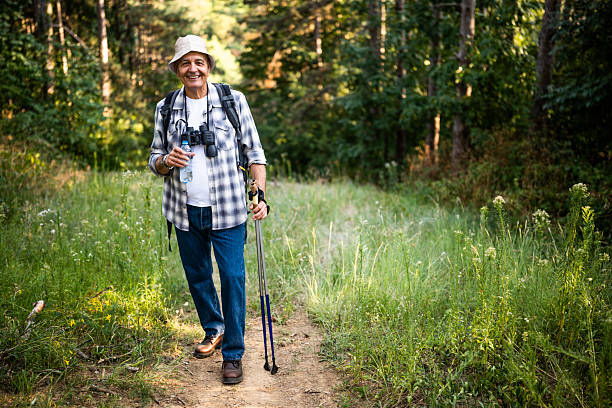 istock Elderly hiker refreshing with bottle of water during forest walk 2235704670