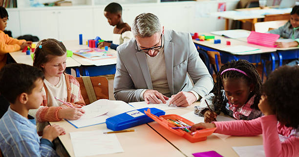 istock Education, man and teacher with children, classroom or knowledge for growth, development or writing. School, educator and person with assignment for kids, learning and curriculum in elementary 2235704776