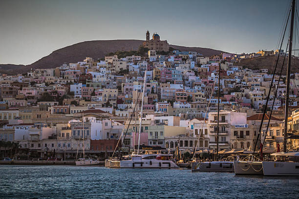 ERMOUPOLI, SYROS, GREECE – AUGUST 29, 2025: View of the harbor with yachts, waterfront buildings and the hillside of Ermoupoli town.